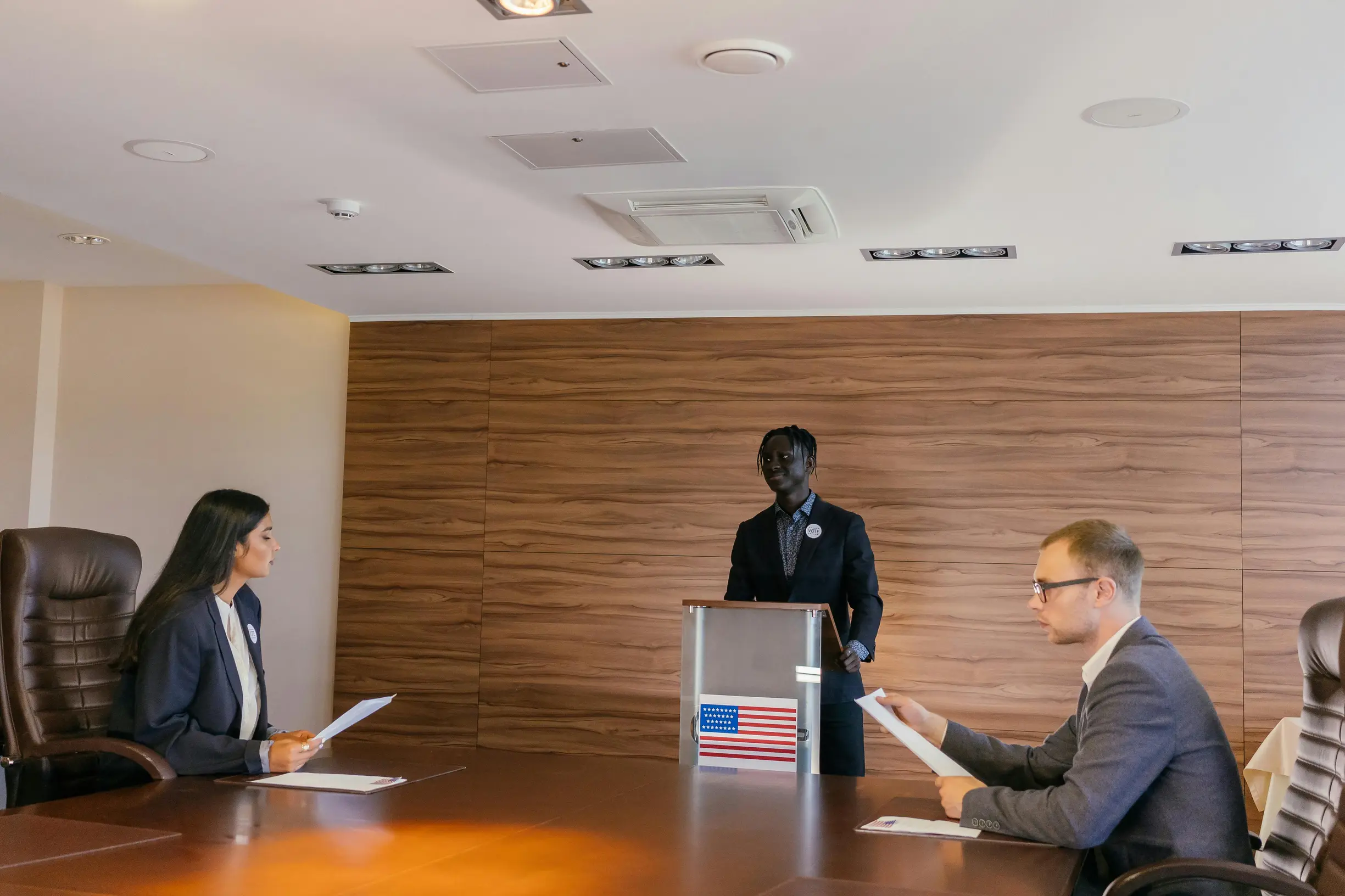 Business professionals engaged in a formal meeting, discussing key topics around a conference table.